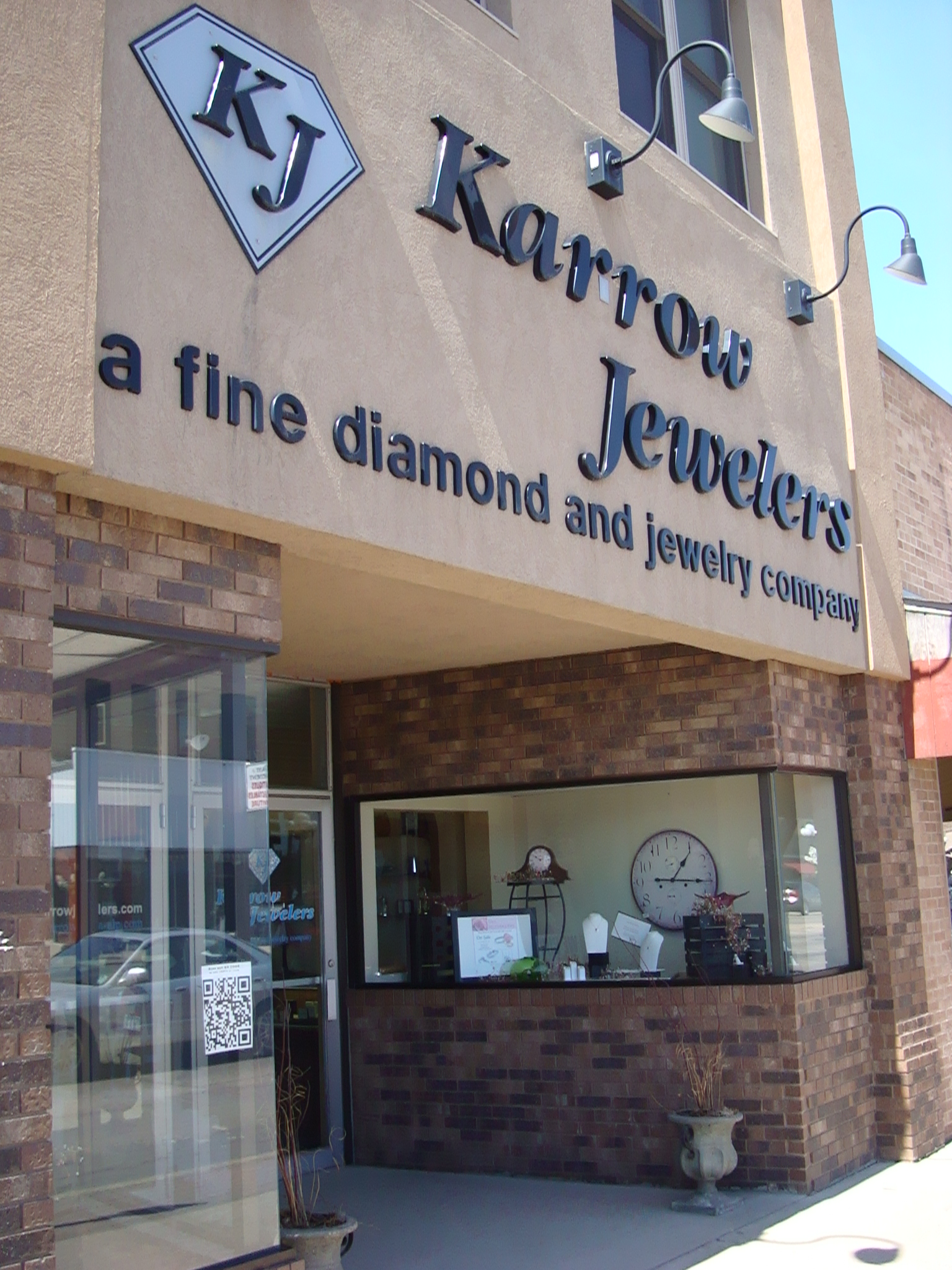 The exterior of Karrow Jewelers, a brick and stucco building with large windows, showcases signage reading "Karrow Jewelers, a fine diamond and jewelry company." A QR code is visible near the entrance.