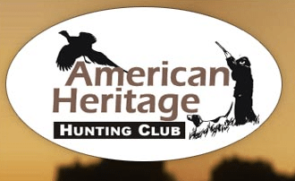 Logo of American Heritage Hunting Club featuring a silhouette of a hunter aiming a rifle, his loyal dog by his side, and a pheasant flying above—all enclosed within an oval shape.