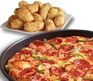 A delicious Dominos Pizza pan pizza topped with pepperoni and green peppers sits in the foreground, while a plate of golden-brown breaded chicken nuggets is in the background.