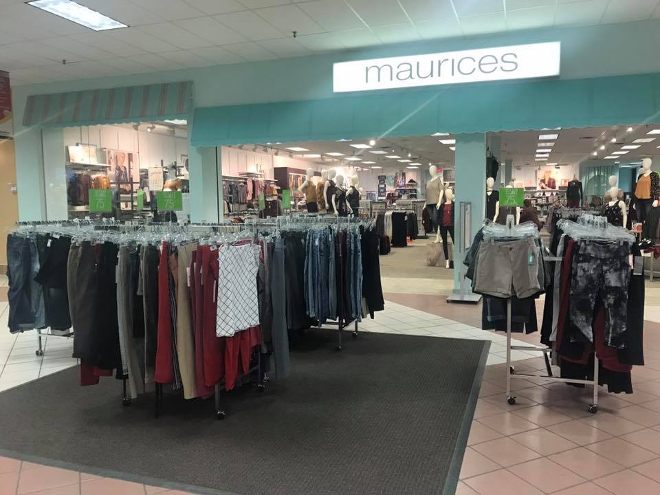 Clothing racks with pants and shorts are displayed at the entrance of a Maurices store in Viking Plaza Mall. The store interior is visible with more clothing and mannequins in the background.