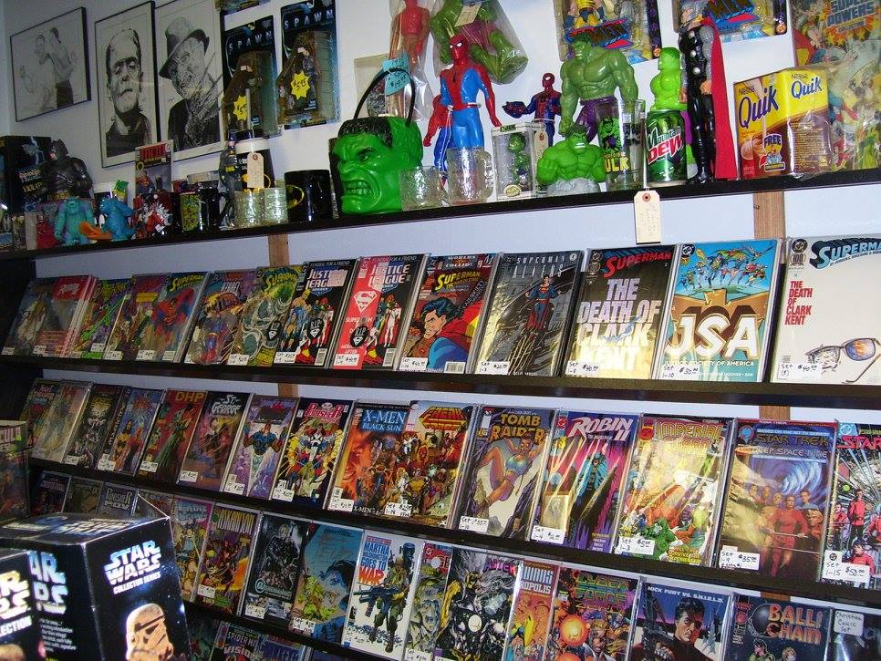 Shelves filled with comic books, superhero action figures, Hidden Treasures Collectibles, and posters. Items include Hulk, Spider-Man, and Superman figures, with colorful comic book covers prominently displayed.