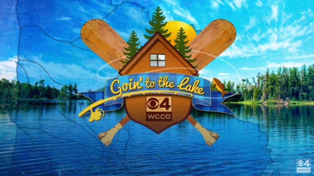 Logo for "Goin’ to the Lake" by CBS 4 WCCO, featuring a cabin, two paddles, pine trees, sun, and water—set against a scenic Alexandria lake and forest background.