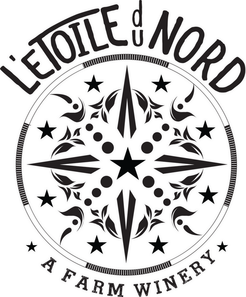 Black and white logo featuring "L’Etoile du Nord" above a decorative compass rose, with "A Farm Winery" below—all in bold, stylized lettering that highlights the L'Etoile du Nord brand.