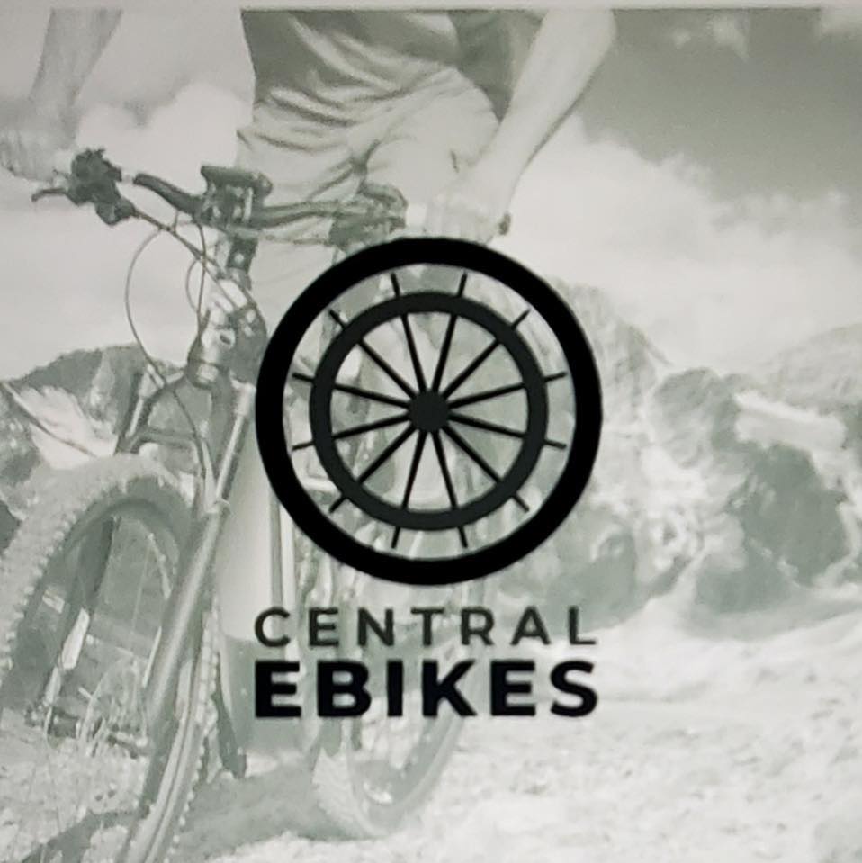 A person stands with a mountain bike outdoors. Overlaid is a circular bicycle wheel logo and the text "Central Ebikes," highlighting adventure and eco-friendly rides. Mountains and sky form a scenic backdrop.