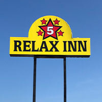 A yellow sign reads "RELAX INN" in black letters, beneath a red star with the number 5 and four smaller stars, set against a clear blue sky—one of the welcoming hotels in Alexandria Minnesota.