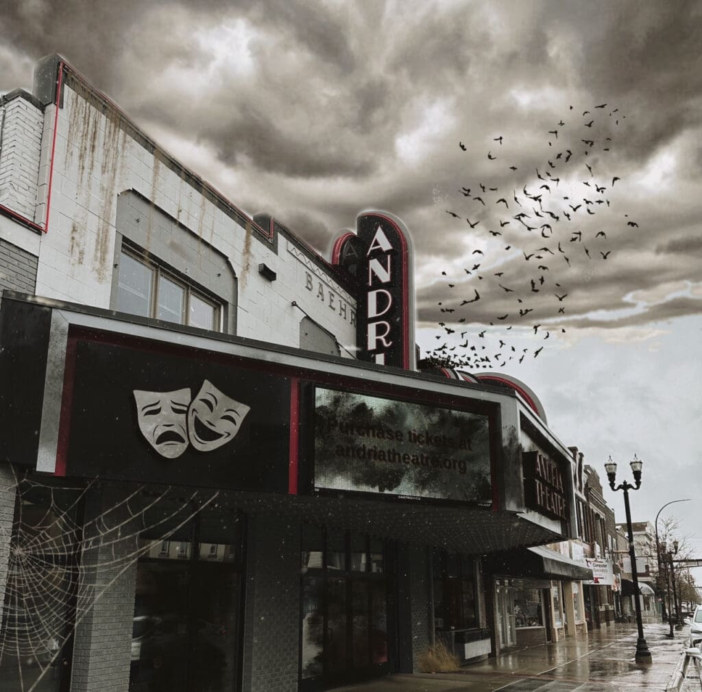 A dark, abandoned theater with peeling paint and a faded sign sits under a stormy, cloudy sky during Alexandria Halloween. Birds fly overhead, a large cobweb hangs by the entrance, and comedy and tragedy masks decorate the marquee.