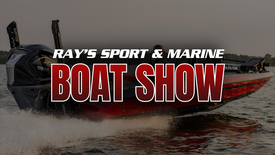 A red speedboat on the water with large white and red text that reads: "Ray's Sport and Marine Spring Boat Show.