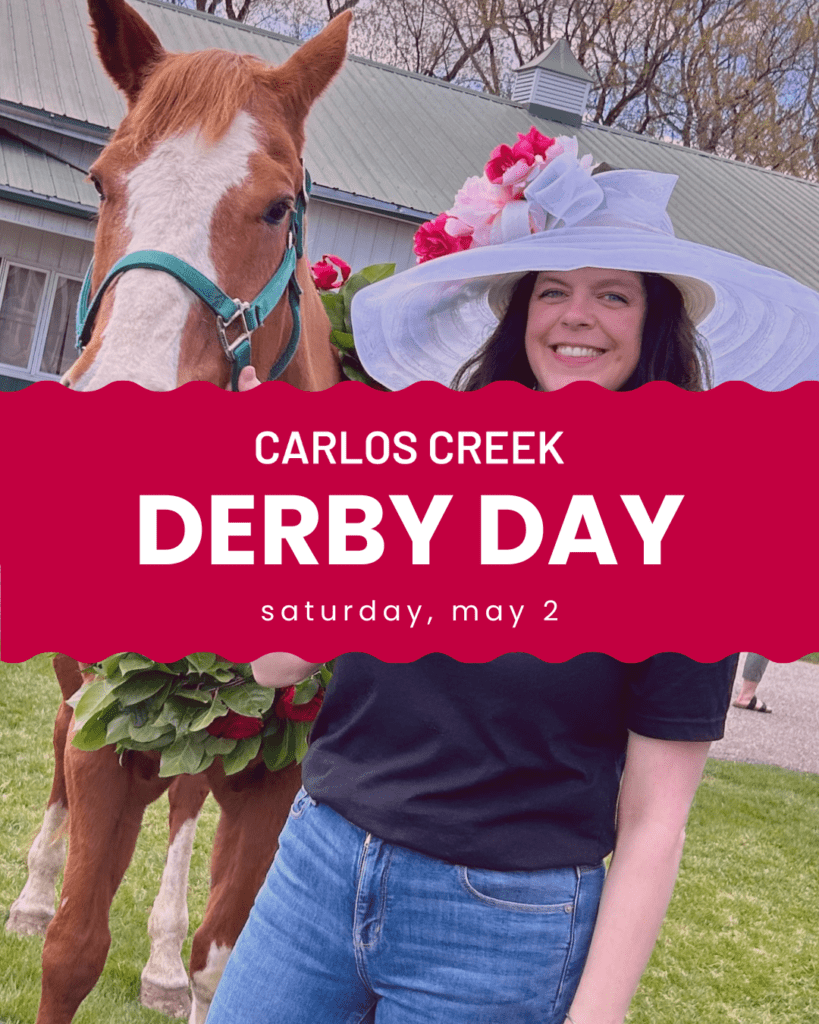 A woman in a large white hat decorated with flowers stands next to a horse wearing a green halter and a garland. Text reads: "Carlos Creek Derby Day, Saturday, May 2." A barn and trees are in the background.