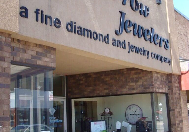 The exterior of Karrow Jewelers, a brick and stucco building with large windows, showcases signage reading "Karrow Jewelers, a fine diamond and jewelry company." A QR code is visible near the entrance.