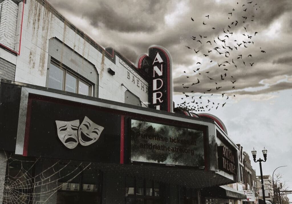 A dark, abandoned theater with peeling paint and a faded sign sits under a stormy, cloudy sky during Alexandria Halloween. Birds fly overhead, a large cobweb hangs by the entrance, and comedy and tragedy masks decorate the marquee.
